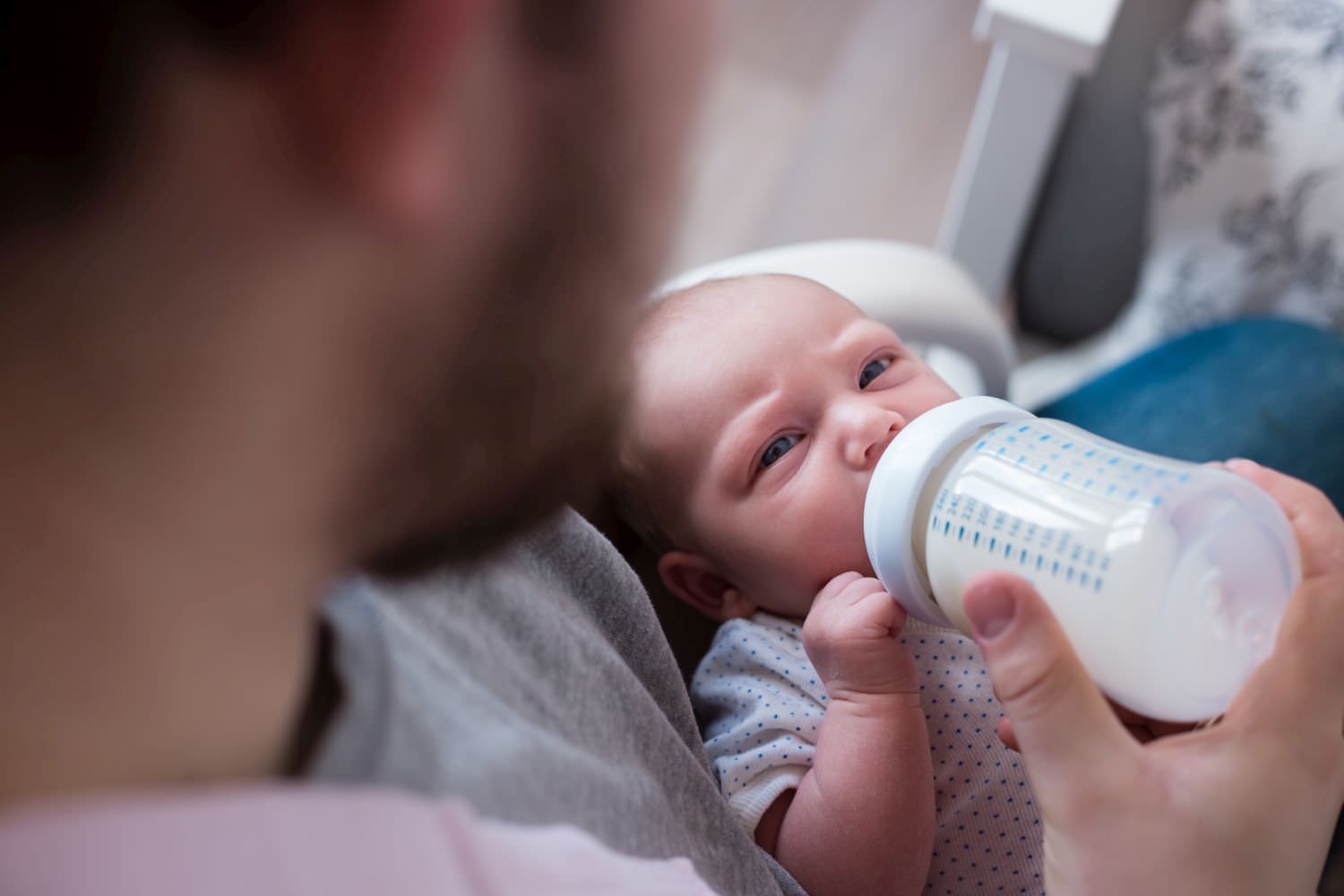 Bild zeigt: Ein Neugeborenes bekommt von seinem Vater die Flasche