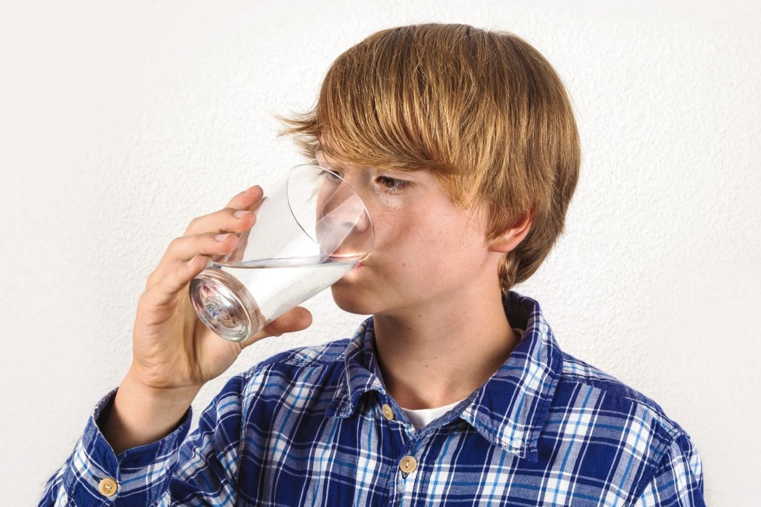 Bild zeigt: Ein Junge trinkt Wasser aus einem Glas