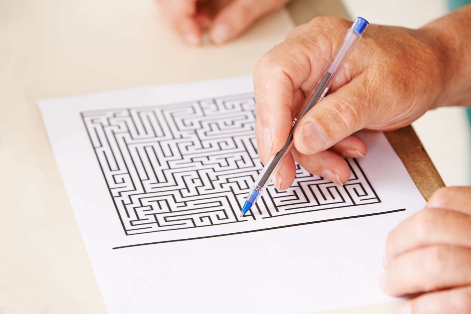 Bild zeigt: Hand eines Senioren mit Stift macht Gedächtnistraining mit einem Labyrinth