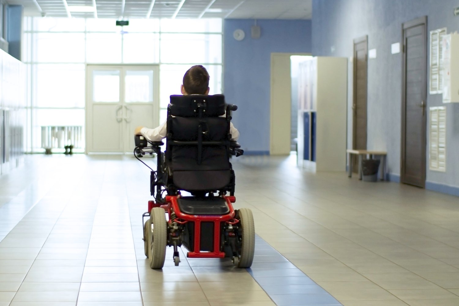 Bild zeigt: Junge mit schwerer Behinderung in einem elektrischen Rollstuhl