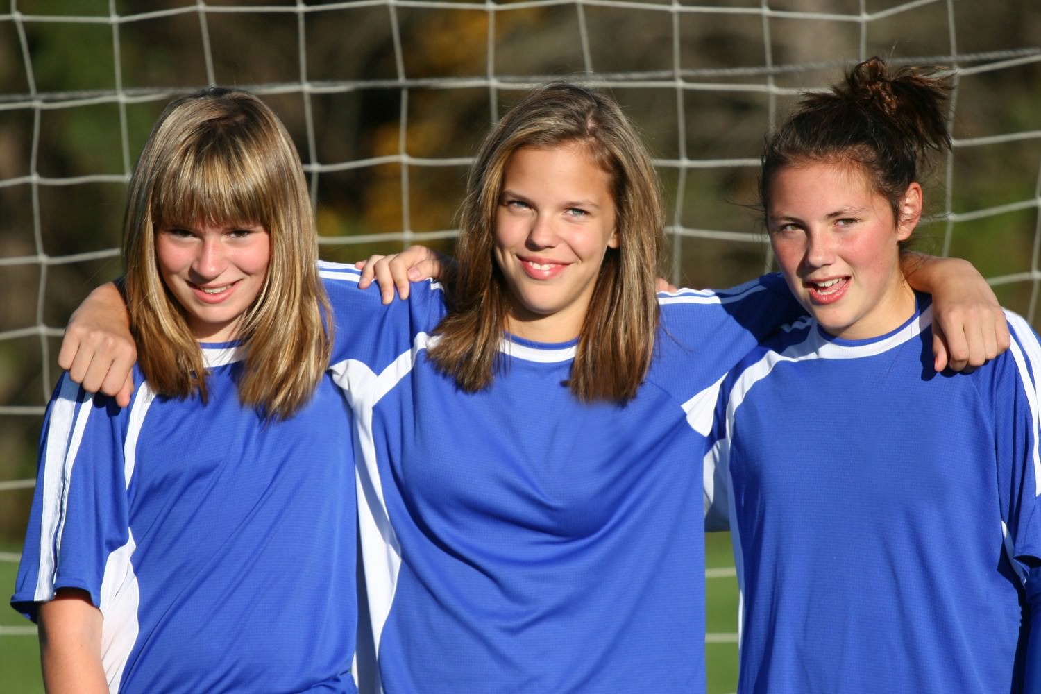 Bild zeigt: Drei Mädchen stehen nebeneinander in einem Fußballtor