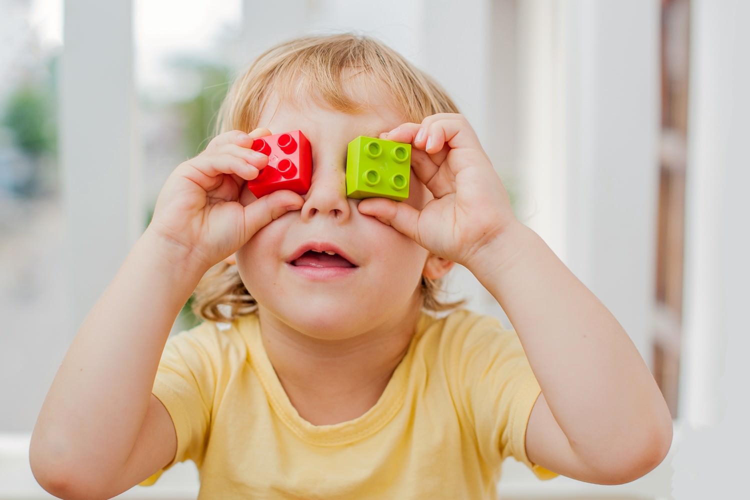 Bild zeigt: Kleinkind hält sich zwei Bauklötze vor die Augen