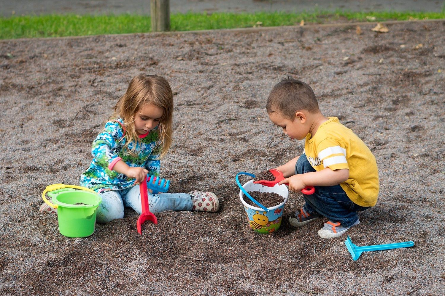 Bild zeigt: Kleines Mädchen und kleiner Junge spielen im Sand