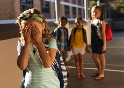 Bild zeigt: Junge Schülerin weint und Kinder dahinter lachen