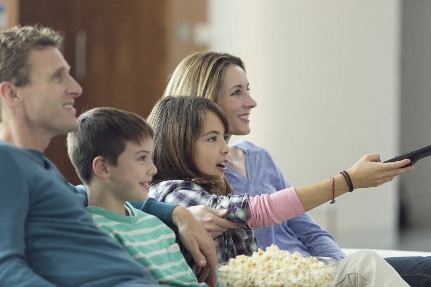 Bild zeigt: Eltern mit Sohn und Tochter sehen gemeinsam fern