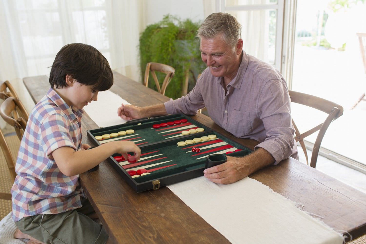 Bild zeigt: Großvater spielt mit seinem Enkel Backgammon