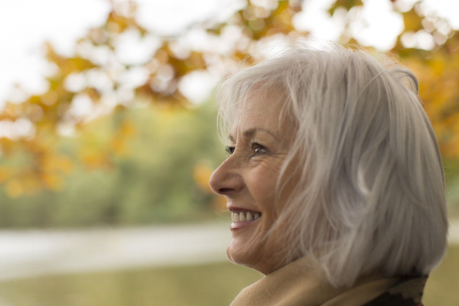 Bild zeigt: Porträt einer älteren lächelnden Frau im Herbst