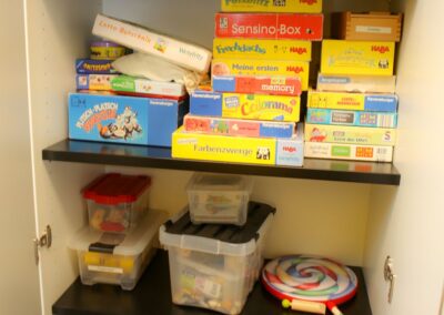 Bild zeigt: Geöffneten Schrank mit Material- und Spielesammlung