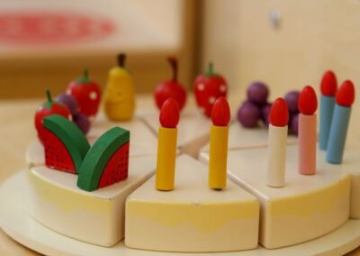 Bild zeigt: Alltagsnahes Spielmaterial als Holzspielzeug in Kuchenform