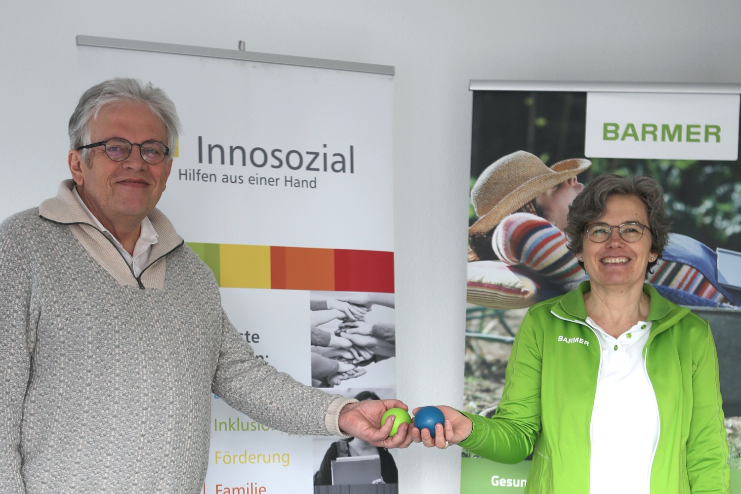 Bild zeigt: Dietmar Zöller und Helga Pieper stehen nebeneinander vor den Roll-ups von Innosozial und der Barmer